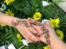 Photo of Mumtaz' work - decorated hands on a flower background